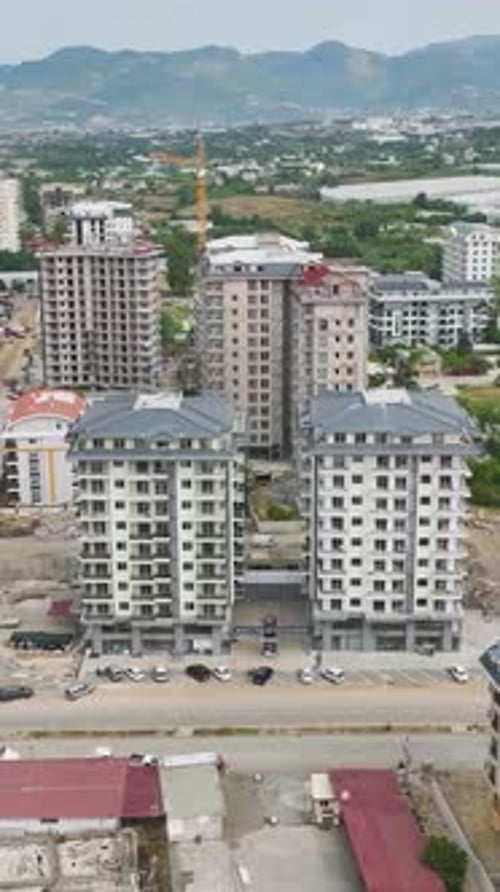Vídeo vertical: máquinas pesadas sientan las bases, mientras que los constructores añaden vidrio para balcones y Fa Ade