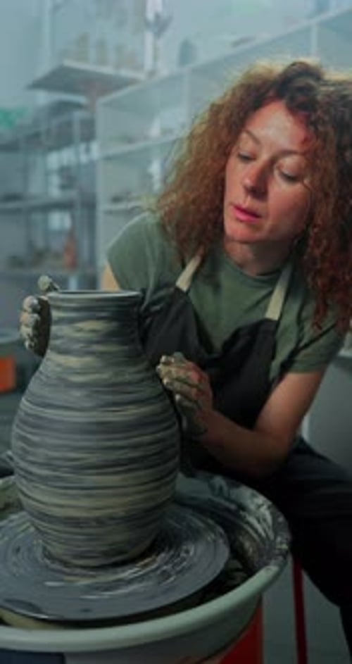 Woman Shaping Pottery on Wheel in Studio