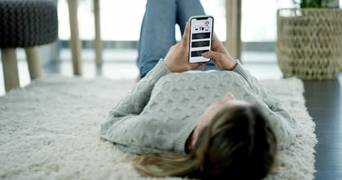 Eine Frau benutzt ihr Handy, während sie sich zu Hause entspannt
