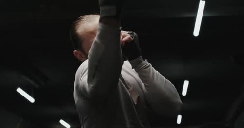 Determined Man Boxing in a Dark Gym