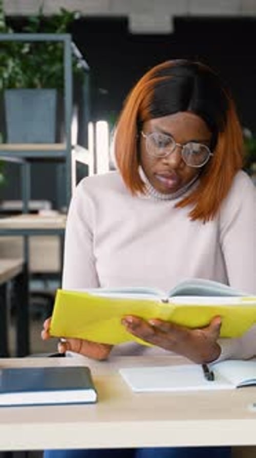 African American Student Preparing for Exams in Library