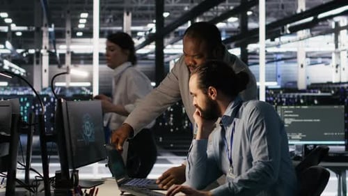 Data Center Engineers Use Laptop Collaborating on Doing AI Software Updates