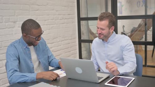 Young People Discussing Work while Sitting in Office