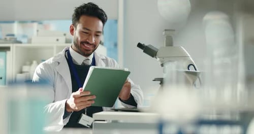 Scientist Smiles while Using Tablet in Bright Lab