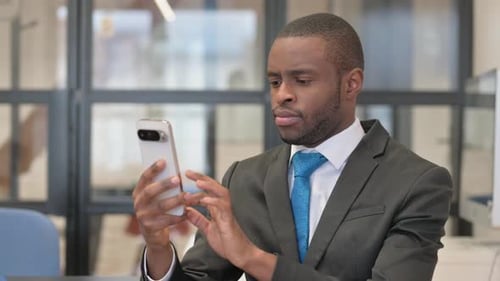 Professional Man Uses Smartphone in Modern Office