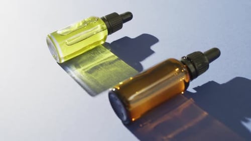 Close up of dropper serum bottles on blue background with copy space