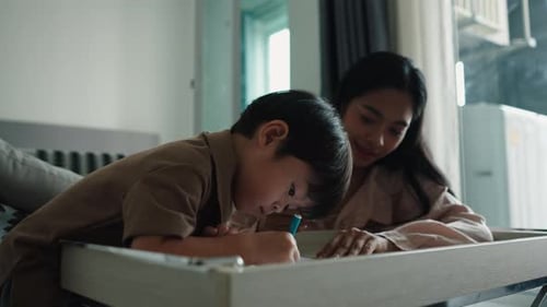 Child Draws with Adult in Home Interior