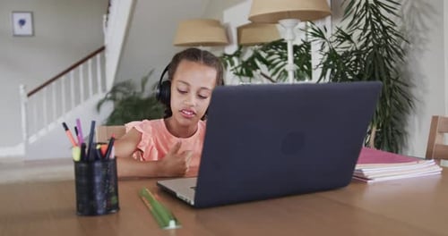 Biracial Boy lernt online mit Laptop am Tisch, Zeitlupe
