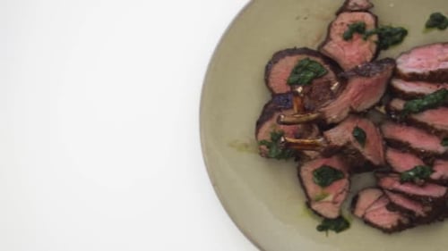 Sliced Lamb with Green Sauce on Plate