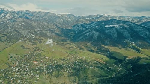 Picturesque Village Nestled Among Snowy Mountains