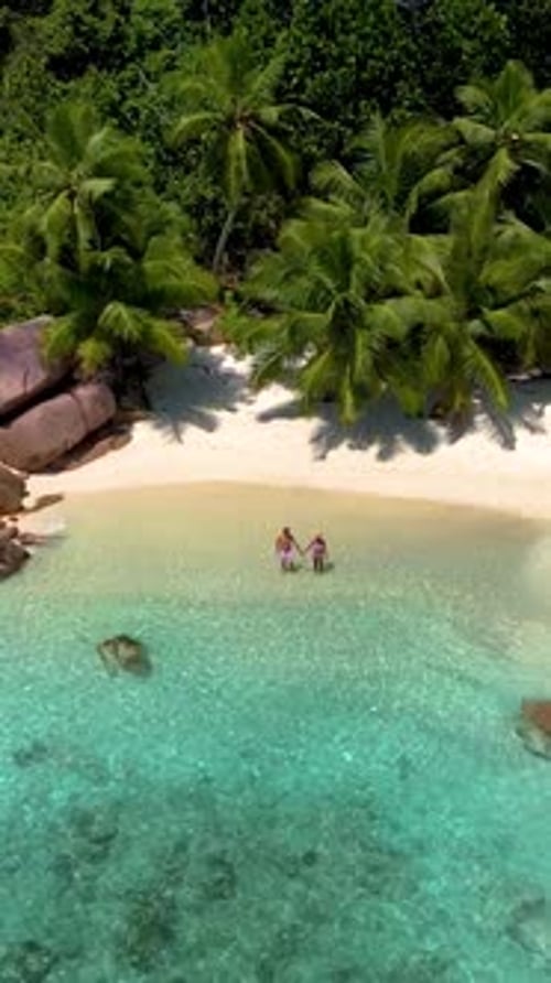 Anse Lazio Praslin Seychelles Young Couple Men and Woman on a Tropical Beach During a Luxury