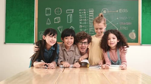 Smiling Students and Teacher in Front of Chalkboard