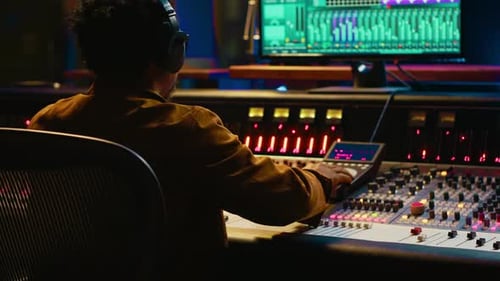 Music Producer Mixing Audio in Studio at Night