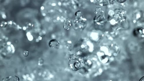 Bubbling water droplets rising and falling in macro