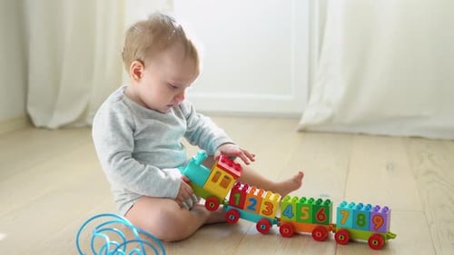 Infant Playing With Colorful Number Block Train