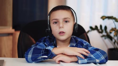 Hübscher Kerl mit kabellosem Headset, der beim Fernunterricht zu Hause reagiert
