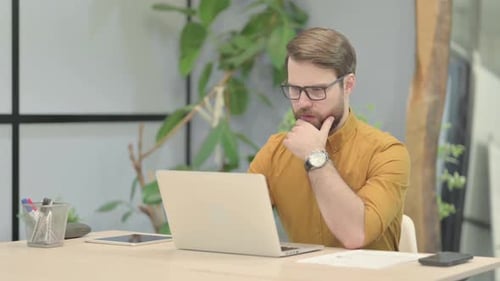 Man with Beard Using Laptop at Desk