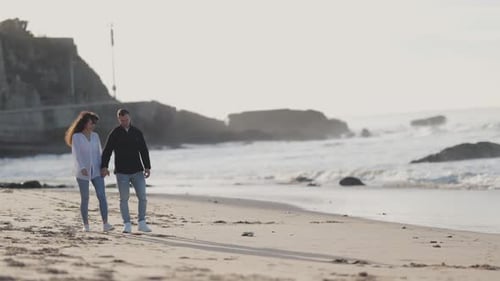 Romantic Couple Walking on Sandy Beach at Sunset