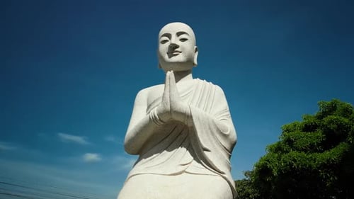Aerial View Flying Around the Huge Big Buddha Statue in Vietnam Against the Backdrop of Green Palms