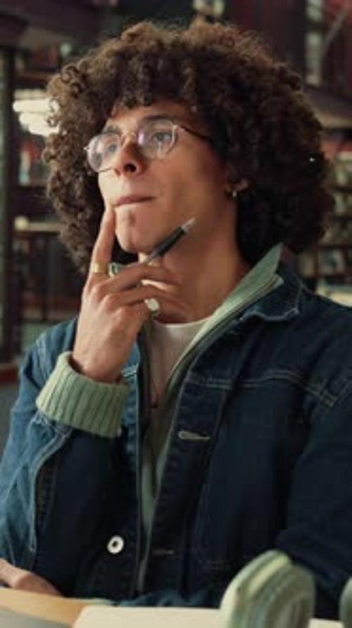 Thinking, student and man in library, education and planning for assignment or academic development