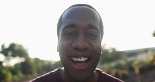 Young African Man Smiling on Camera in the City with Sunset In