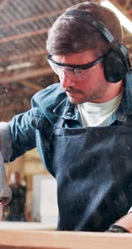 Man, sawing and carpentry machine in workshop for cutting wood, timber design and manufacturing