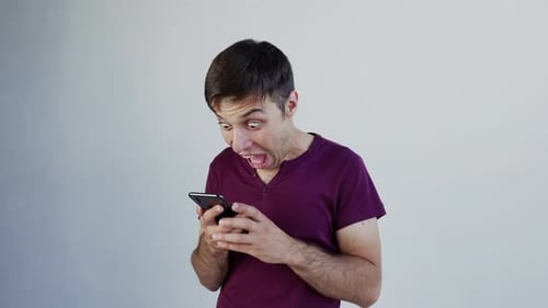 Man Reacts with Excitement to Smartphone News