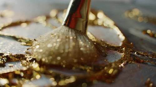 Aufbringen von Blattgold auf Kunstharzkunst