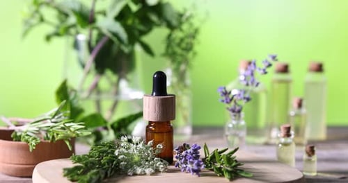 Woman putting bottles of essential oils onto table, closeup