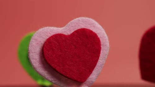 Colorful Felt Heart Decorations on Pink Background