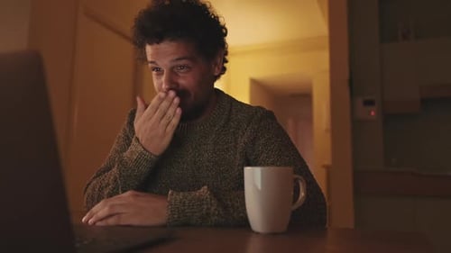 Man Happily Talking on Laptop Video Call at Home