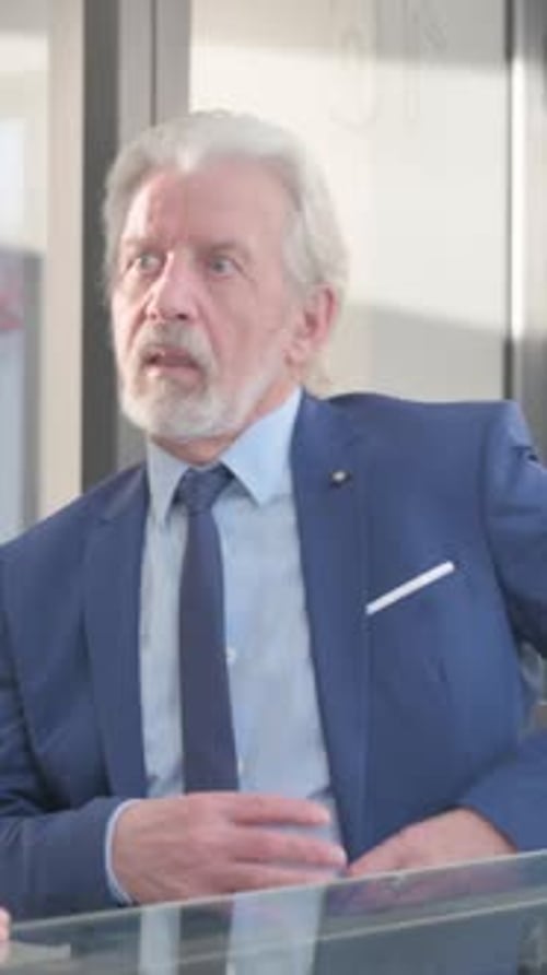 Senior Businessman in Suit Talking in Office Setting