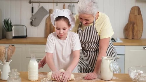 Child Kneading Dough with Adult in Kitchen