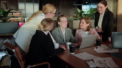 Confident Group Business Woman in Business Clothes Sitting at a Table in the Office in Front of a