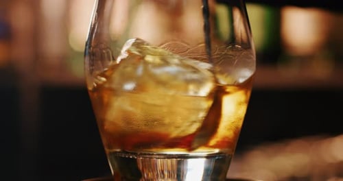 Close up of a professional bartender is mixing an alcoholic cocktail with professional crystal lon