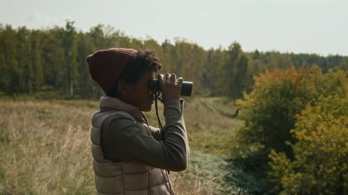 Person Looking Through Binoculars in Rural Setting