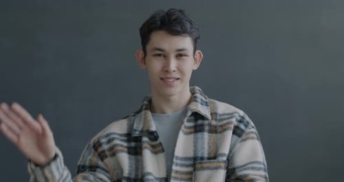 Smiling Young Adult Waving at the Camera