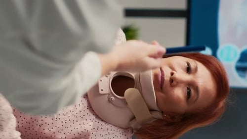 Vertikales Video Asiatischer Patient mit Halskragen bei Beratung mit einem Spezialisten
