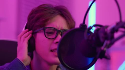 Young Adult Recording Audio with Microphone and Headphones