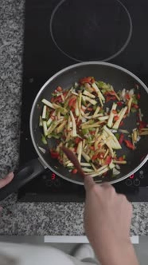 Top View Of A Person Cooking Healthy Vegetable Meal Using Electric Stove Overhead