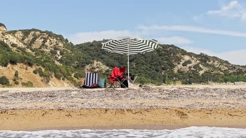chairs and beach umbrellas on the sand at the seaside