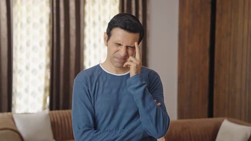 Man Thinking Deeply in Living Room