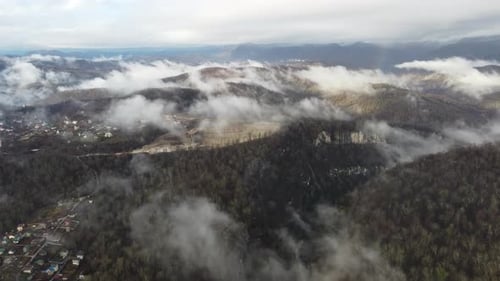 View of the Autumn Village in the Mountains Through the Clouds