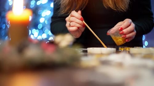 A Woman with a Stick Knife Carefully Melts the Small Details in the Product