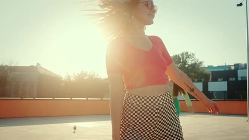 Young Females Spinning While Riding Quad Skates on Rooftop