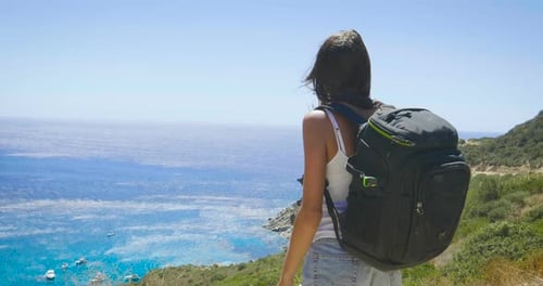 A tourist photographer woman holds a phone, feels free with a backpack on her back, a wonderfully