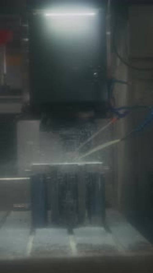 Vertikal der Fräsmaschine, die Kühlflüssigkeit über das Metallteil in der Anlage spritzt