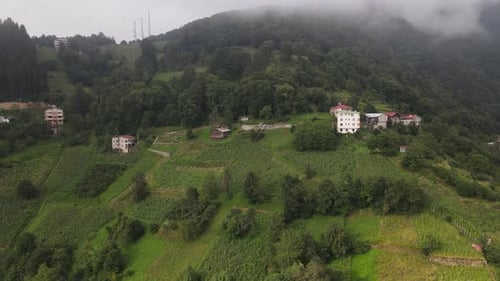 Drone view of foggy mountain and rural settlement, rainy plateau view