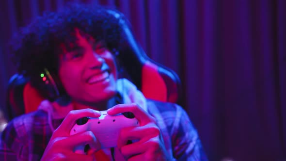 Playing video games, excited man using controller and wearing ...