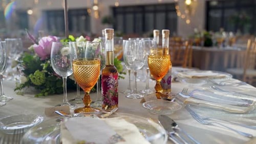 Decoration of wedding table with flowers, glasses and gift wine. Slow rotation camera movement.